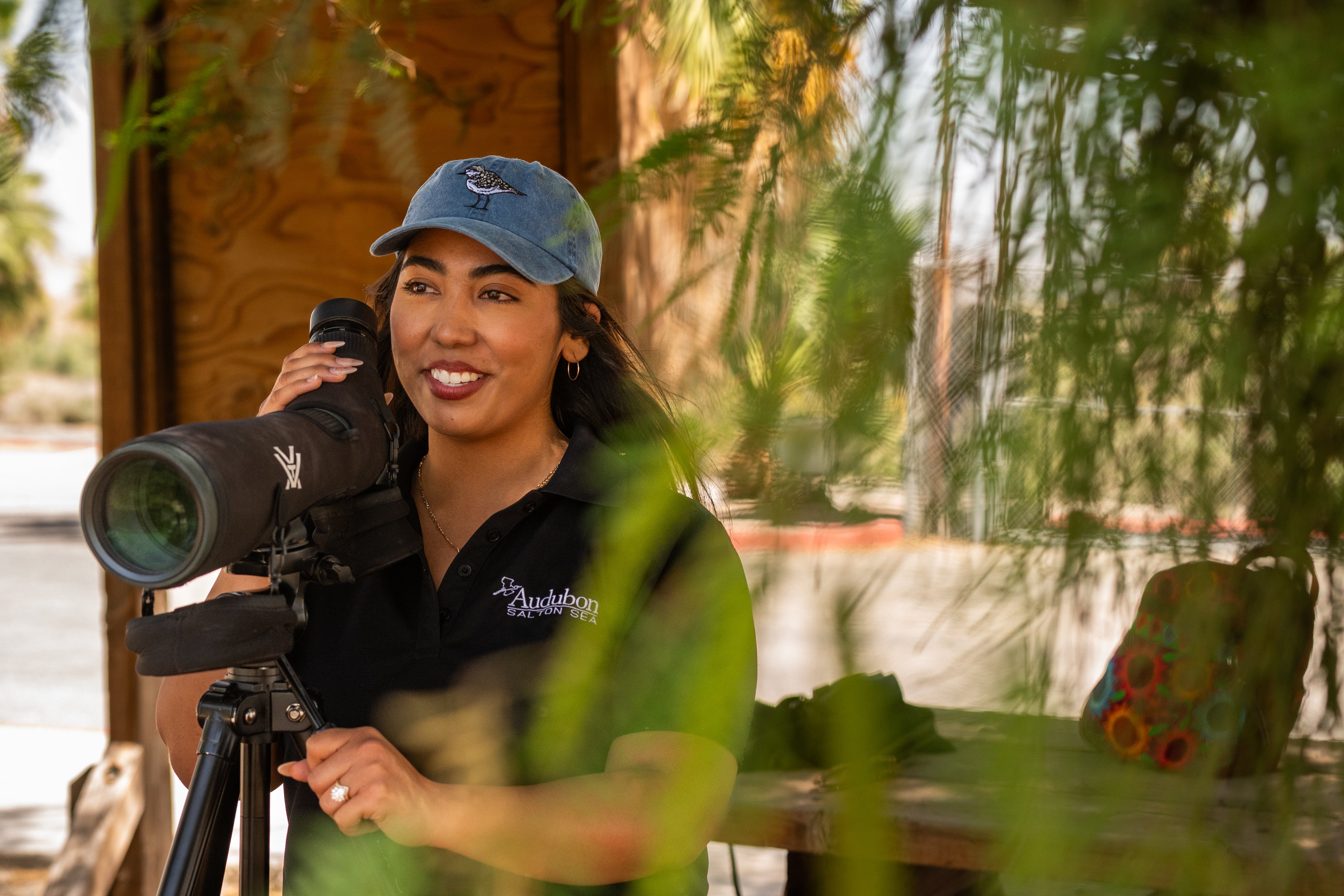 Picture of Camila Bautista in front of a birding scope, at the Salton Sea